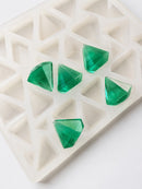 Angled product photo of a 3.5mL diamond gummy mold with 173 cavities and translucent emerald green diamond gummies