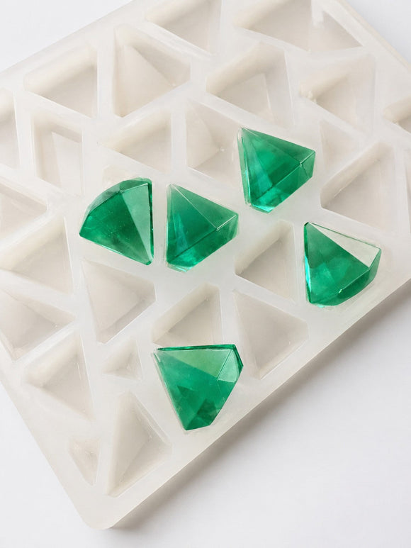 Angled product photo of a 3.5mL diamond gummy mold with 173 cavities and translucent emerald green diamond gummies